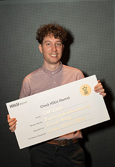 Strahlend zeigt Samuel Herzog, Gewinner des Alumni Förderpreis der Hochschule Luzern seinen Scheck.