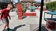 Junge spielt auf Stadtplatz