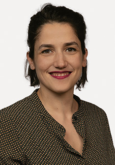 Portrait von der braunhaarigen Anastasia Stamatiou in einer braunen Bluse