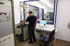 Ein Student nimmt im Werkstoffprüflabor einen dynamischen Dauerschwingversuch vor