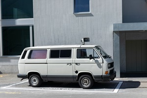 Ein alter weisser VW Bus steht auf einem Parkplatz der mit «Cinema Car» auf dem Boden angeschrieben ist.