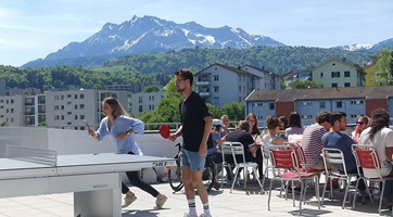 Im Sommer ist die Terrasse beliebt und belebt. Studierende und Mitarbeitende können entspannt essen, Pingpong spielen oder einfach mal durchatmen und die Aussicht auf den Pilatus geniessen.