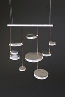 Ranja Issa: Der AURA Kronleuchter verleiht jedem öffentlichen Raum eine angenehme, feierliche und einladende Atmosphäre, bei der das reflektierende Lichtspiel der Lichtkörper an Wänden und Boden den Betrachter sofort in seinen Bann zieht. 