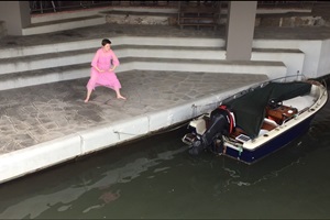 Eine Frau in rosa Kleid an einer Bootanlegestelle