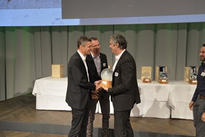 Jurymitglied Stefan Cadosch übergibt den Watt d'Or an Hanspeter Bürgi, Leiter Atelier Solar Decathlon. (Bild BFE)