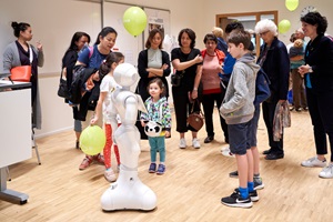 Besucherinnen und Besucher sprechen am Open Day des Campus Zug-Rotkreuz mit dem Roboter Pepper.
