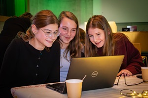 Drei junge Mädchen schauen gemeinsam in einen Laptop