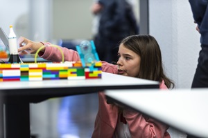 Mädchen bastelt an ihrem Projekt für die First Lego League