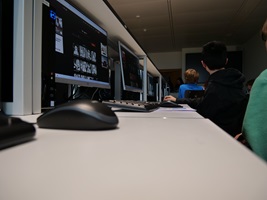 Kinder sitzen im einem Raum mit Computern