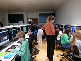 Eine Unterrichtsszene in einem Raum mit Kindern und Computern