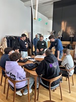 Eine Gruppe junger Männer sitzen an einem Tisch und besprechen etwas