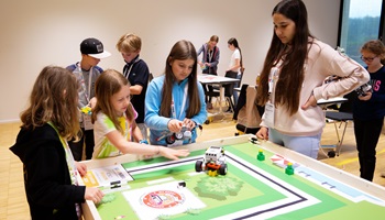 Teilnehmende der World Robot Olympiad stellen Roboter vor