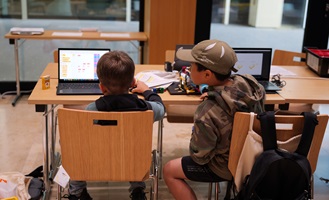 Zwei Jungen arbeiten an Laptops