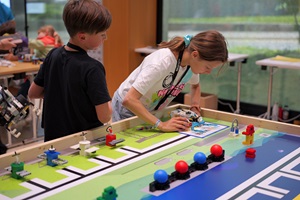 Zwei Kinder arbeiten an einem Tisch mit Roboterlabyrint