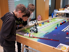 Zwei Kinder arbeiten an einem Tisch mit Roboterlabyrint