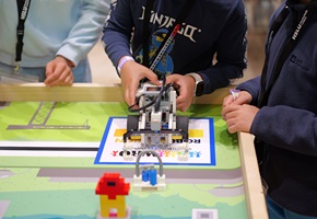 Ein Junge hält einen Lego-Roboter