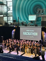 Eine grosse Gruppe junger Menschen steht vor einer Projektion 