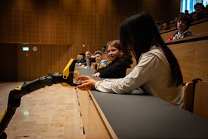 Ein Mädchen greift Schokolade von einem Roboter