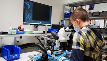 Ein Junge schaut durch ein Mikroskop