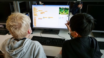 Zwei Jungen schauen auf einen Computer-Bildschirm