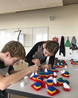 Ein Mädchen und ein Junge stecken Lego-Modelle zusammen