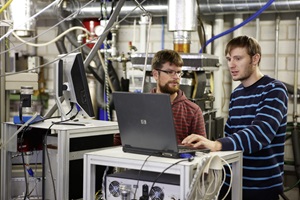 Mitarbeiter bei der Feinstaubmessung an einem Stückholzofen im Labor.