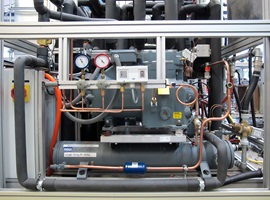 Das Bild zeigt die Detailansicht der Kälteanlage des Prüfstands Wärmemodul. Zu erkennen sind inbesondere der grosse Kolbenkompressor sowie der Rohrbündelkondensator.