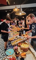 Reisegruppe bedient sich an einem reichhaltigen Buffet mit verschiedenen Speisen in Barcelona.