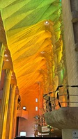 Blick auf die markante, farbig beleuchtete Deckenkonstruktion der Sagrada Família in Barcelona.