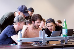 Students discuss measurement results and simulations at a technical test setup