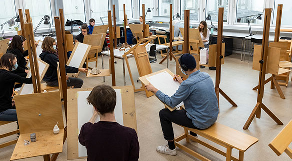 Studierende von Illustration Nonfiction zeichnen ab Modell mit Stativen