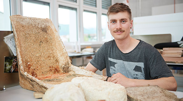 Objektdesign-Absolvent Valentin Küng (Wolfhalden AR) füttert seinen Stuhl und lässt ihn in Form wachsen. Denn er besteht aus einem Verbundstoff von Pilzwurzel und Holzspänen. Bild: Fabian Biasio