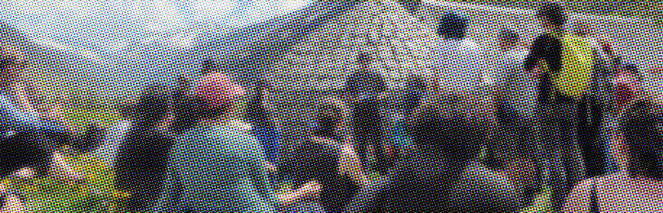 Menschen hören einen Vortrag vor einem Steinhaufen in den Bergen