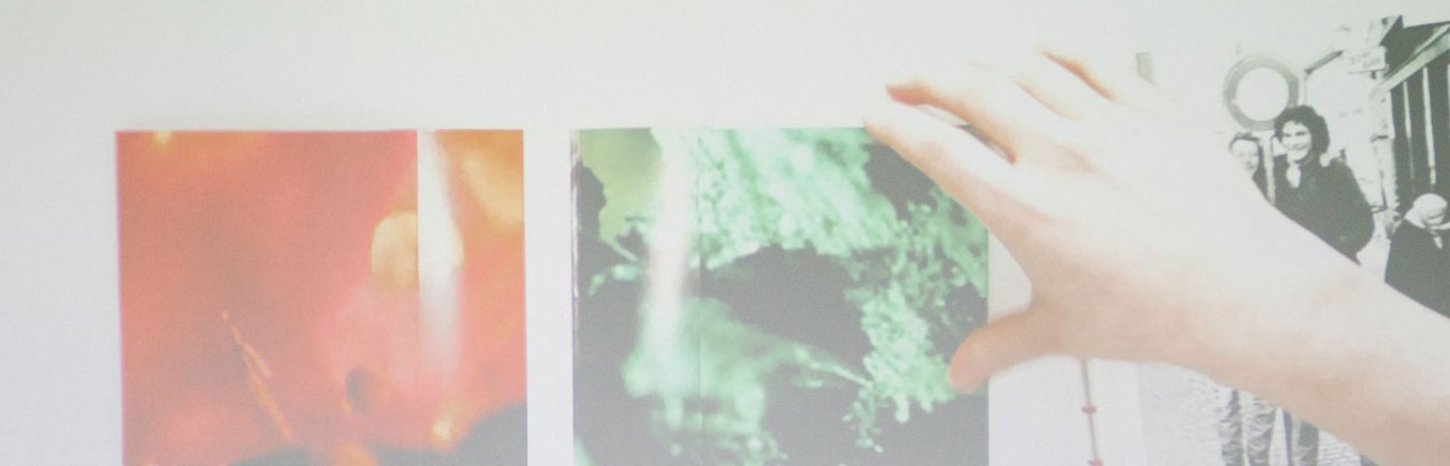 Eine Hand hängt ein Bild auf