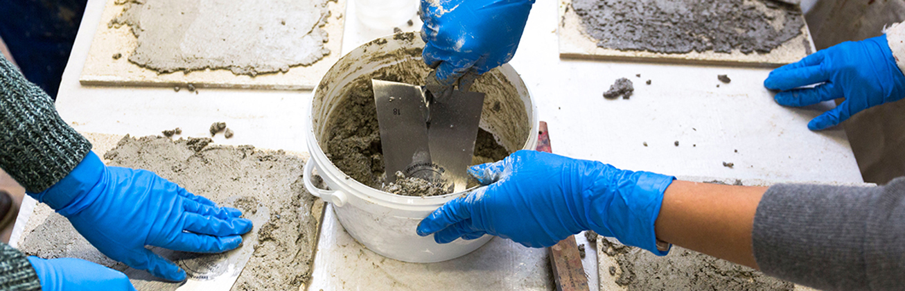 Das Bild zeigt Hände die mit Verputz arbeiten