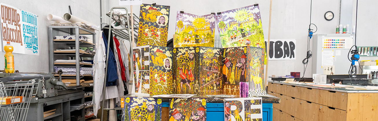 Arbeiten von Studierenden auf einem blauen Wagen in der Werkstatt