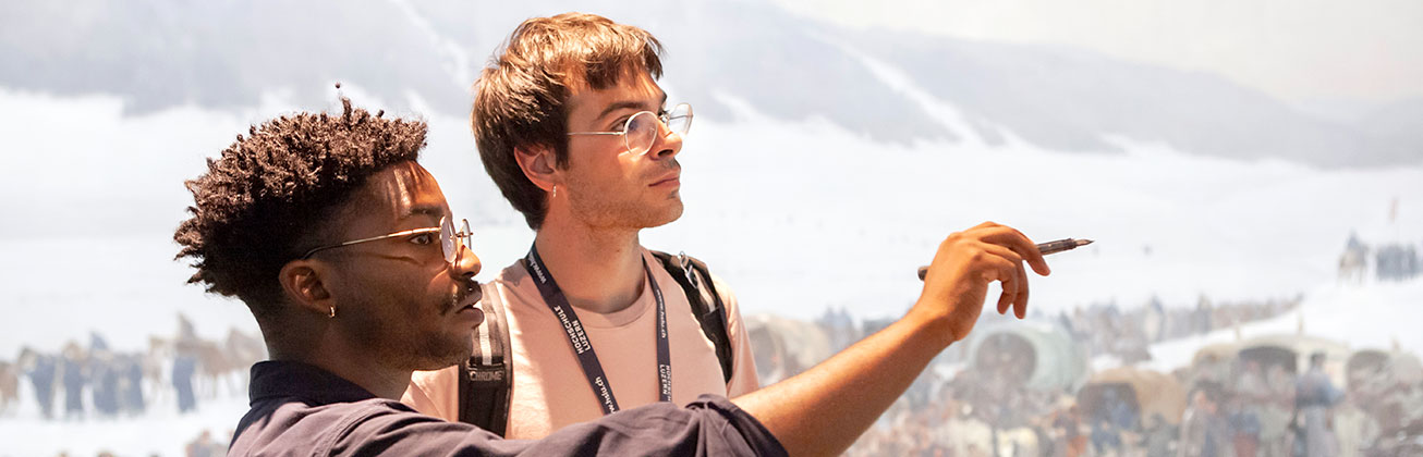 Zwei Studierende besprechen eine Ausstellung