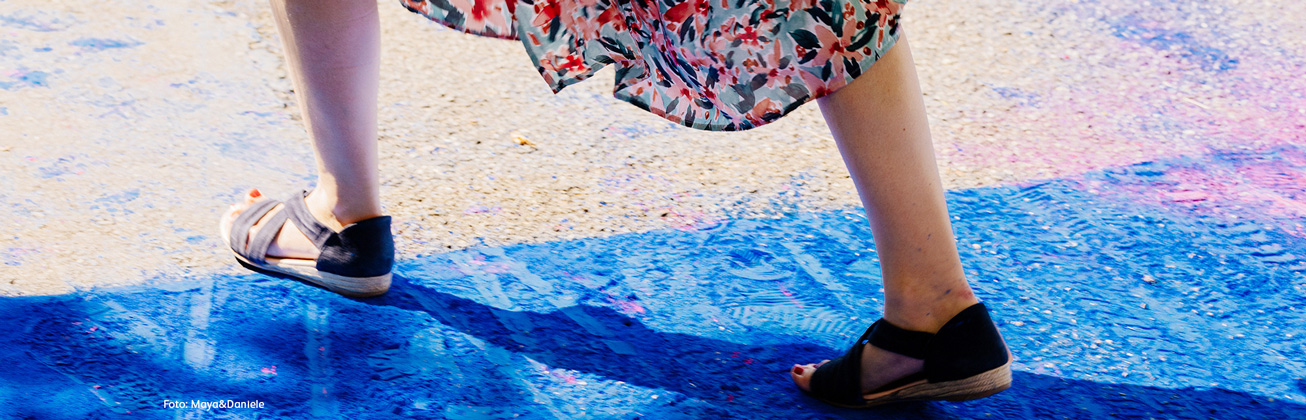 Frau läuft über Boden mit blauem Farbpulver
