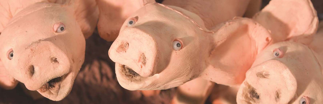     Kill Your Darlings: Nahaufnahme mehrerer rosafarbener Schweinefiguren mit grossen Ohren und weit geöffneten Mäulern, die dicht nebeneinander in die Kamera blicken.