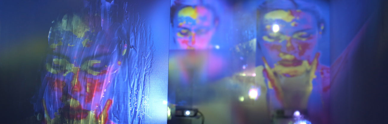 Ein blauer Hintergrund, auf dem verschiedene farbige Abdrücke von Gesichtern sind