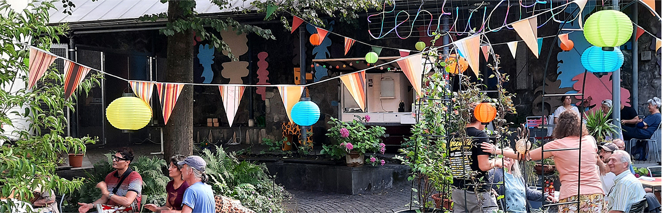Bunt gestaltete Plakate und Drucksachen im öffentlichen Raum sowie Szenen eines lebendigen Quartiertreffs mit Menschen, Pflanzen und gemeinschaftlichen Aktivitäten im Aussenbereich.