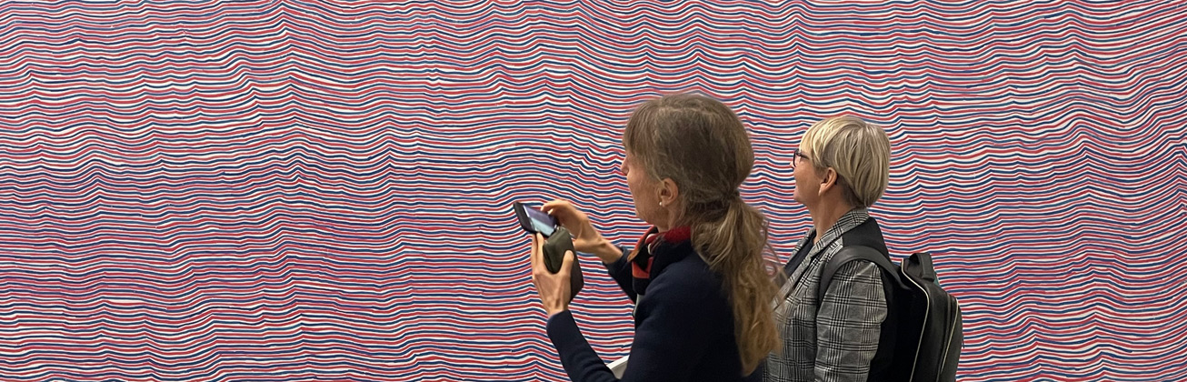 Zwei Personen vor einem Kunstwerk aus Linien.