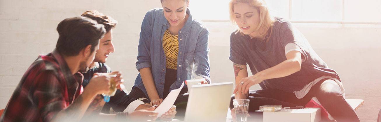 Vier Studierende arbeiten zusammen an Notebook