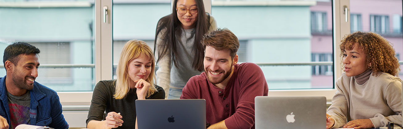 Fünf Studierende arbeiten zusammen an Notebooks