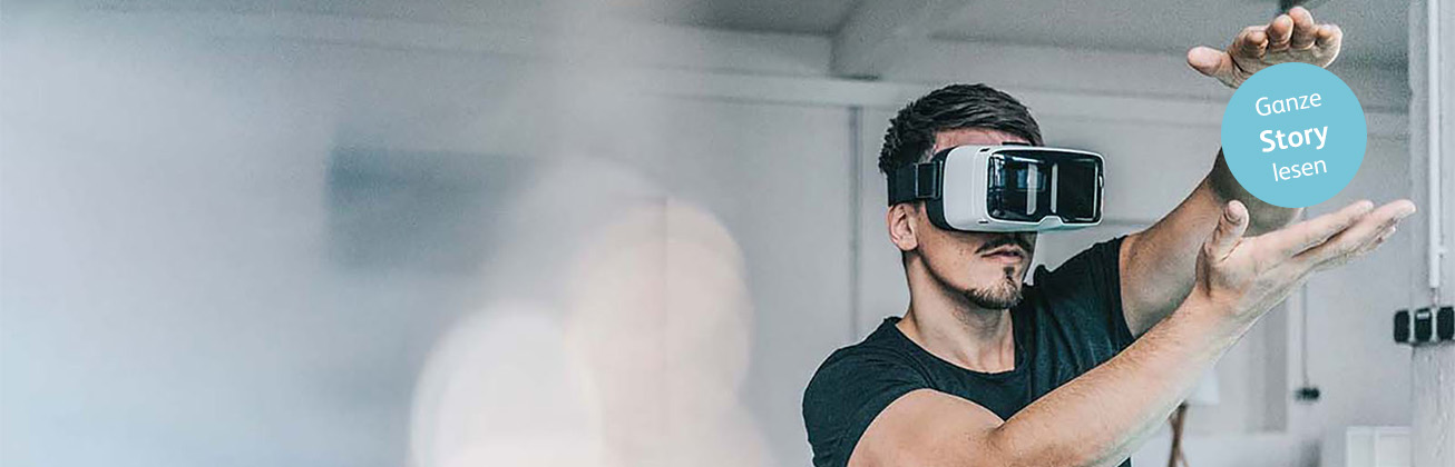 Ein Mann mit Virtual Reality-Brille streckt seine Arme in die Höhe und hält so ein Button, auf dem  