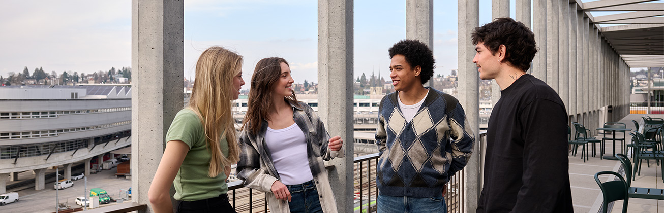 Vier Studierende tauschen sich auf der Terrasse aus
