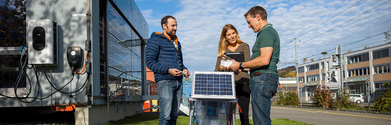 Portrait von Menschen um ein Solar-Panel