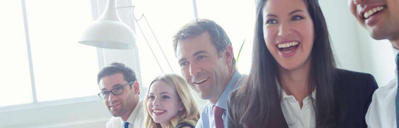 Fünf lachende Menschen in einem Büro