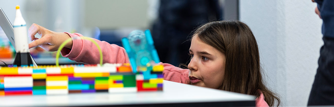Mädchen baut mit Lego die Stadt der Zukunft
