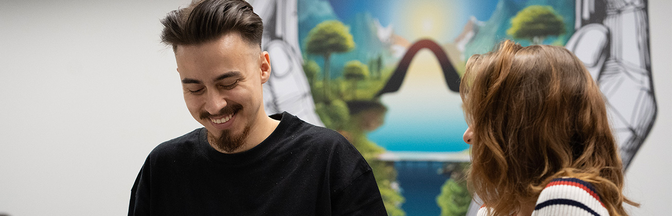 Ein junger Mann mit Bart lacht